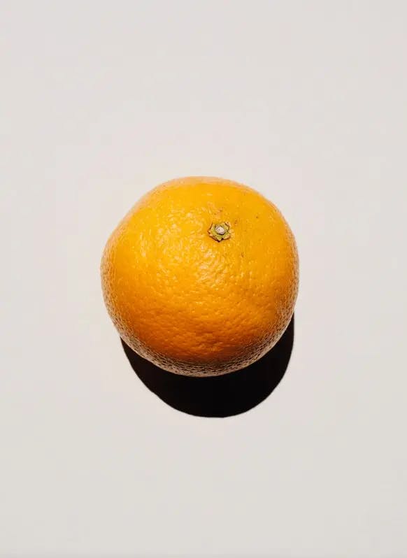 gul citrusfrukt mot vit bakgrund
